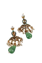 Pair of ornate earrings with green stones on a white background
