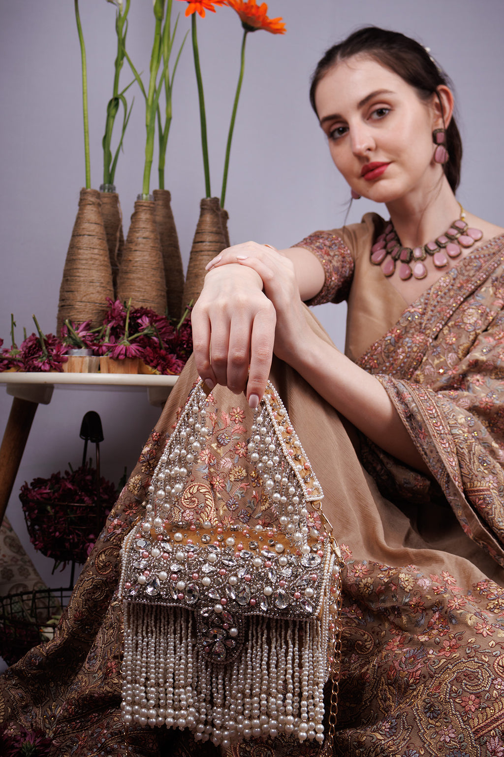 Gold handcrafted evening handbag with stone pearl bead embellishment fringe detail top handle and detachable chain wedding festive wear