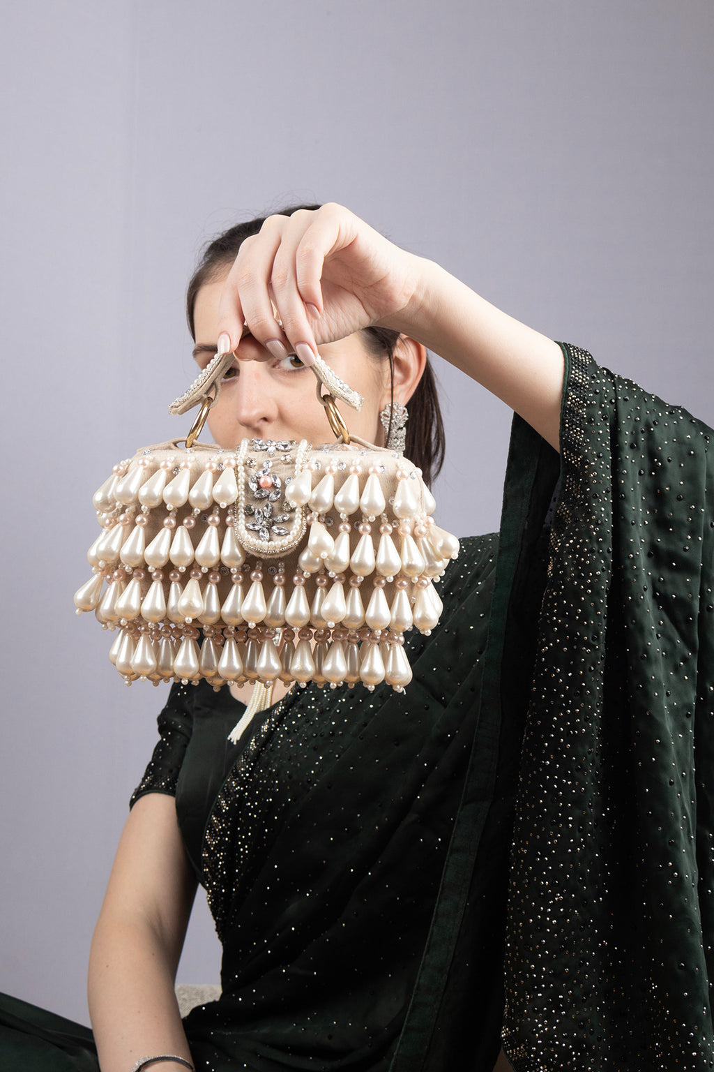 Handcrafted pearl clutch bag with traditional pearl detailing short handle and detachable shoulder chain for festive and wedding occasions