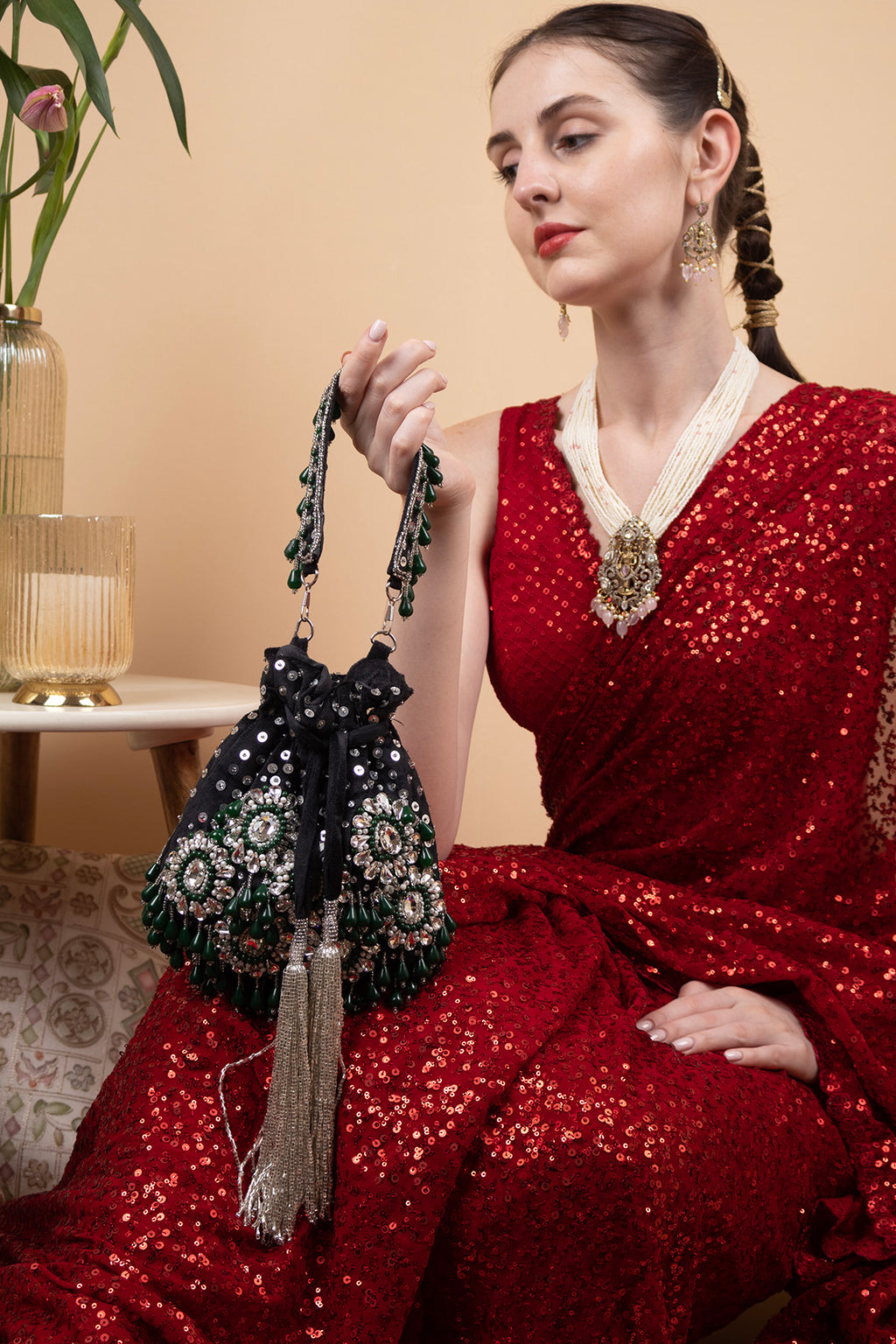 Black handcrafted potli bag with sequin cutdana beadwork stones and drawstring closure for festive and wedding wear
