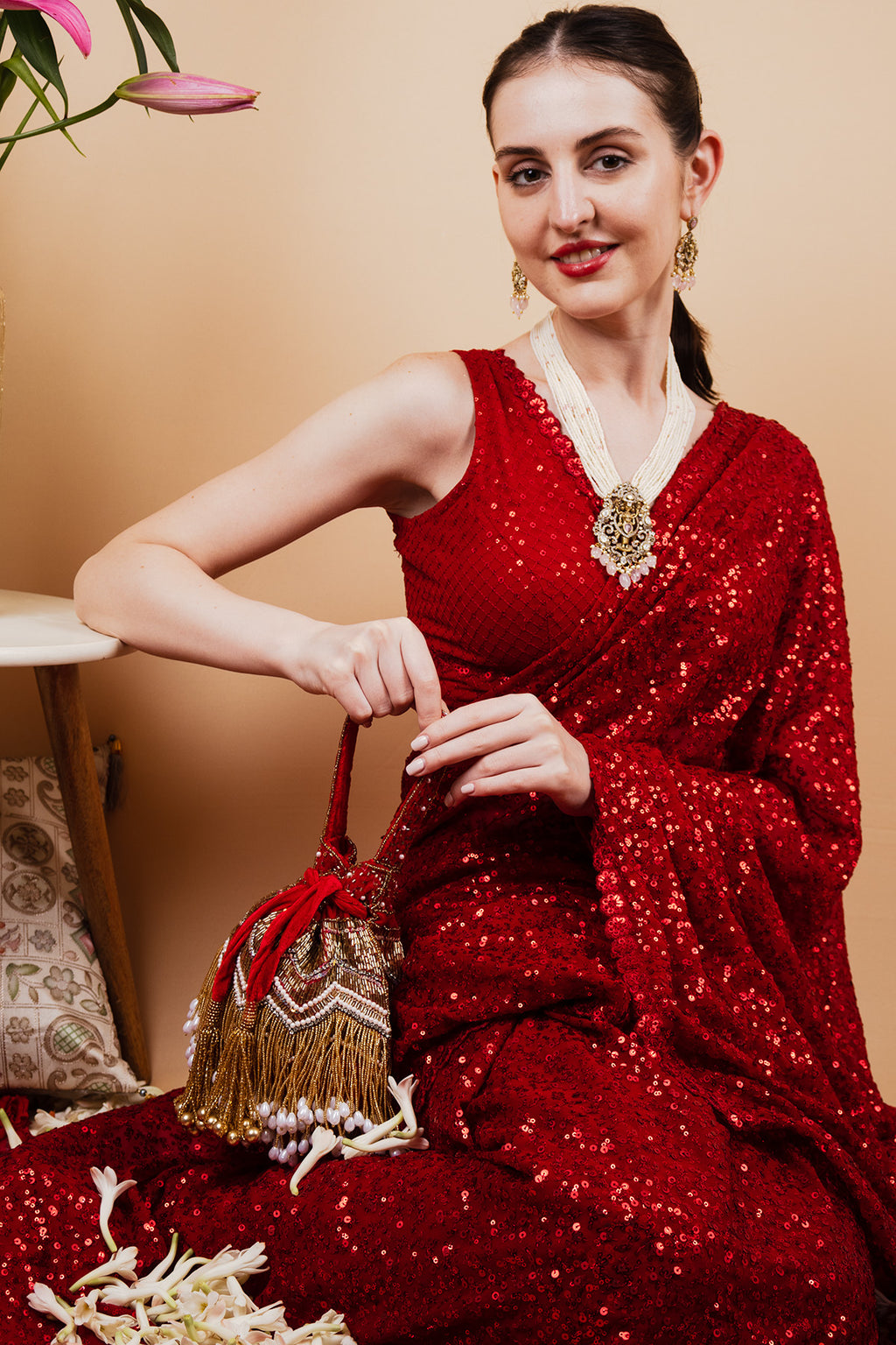 Red velvet potli bag with cutdana pearl and stone embellishments with drawstring and handle for wedding and festive wear