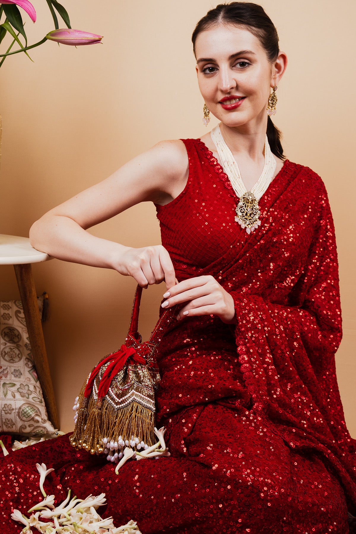 Red velvet potli bag with cutdana pearl and stone embellishments with drawstring and handle for wedding and festive wear