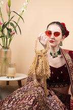 Suede potli bag with cutdana and crystal work cascading embellishments drawstring closure and handle for wedding and festive wear