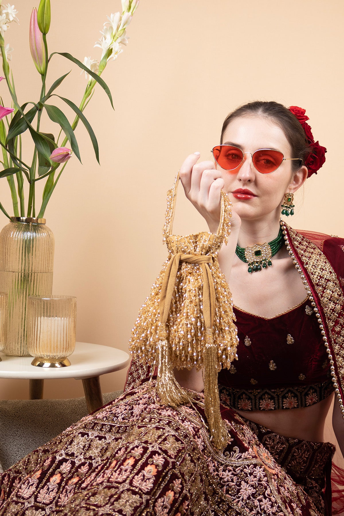 Suede potli bag with cutdana and crystal work cascading embellishments drawstring closure and handle for wedding and festive wear