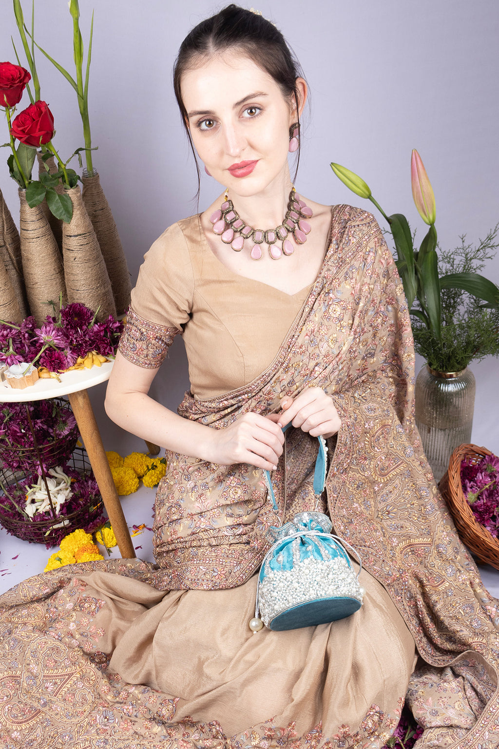 Blue raw silk potli bag with sequins cutdana and pearl embellishments with tassel for wedding and festive wear
