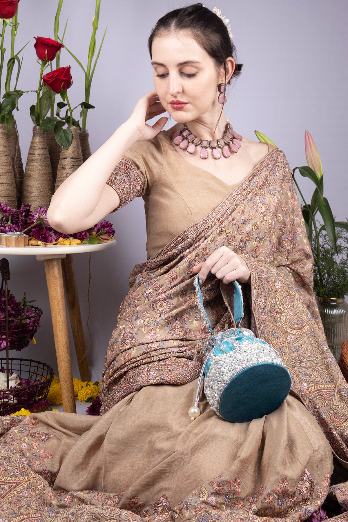 Blue raw silk potli bag with sequins cutdana and pearl embellishments with tassel for wedding and festive wear