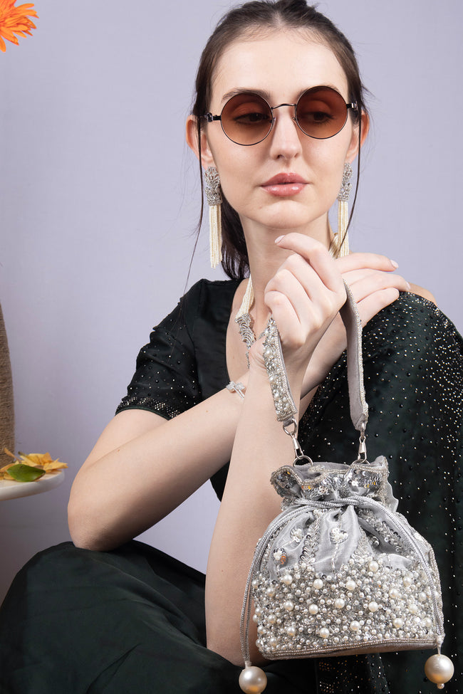 Silver potli bag with cutdana pearl and sequin embellishments on raw silk fabric with tassel for wedding and festive wear Hover Image